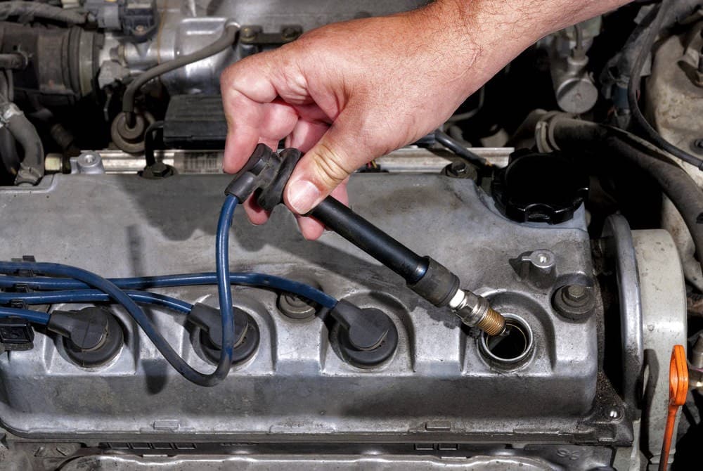 visual inspection of engine spark plugs  a man